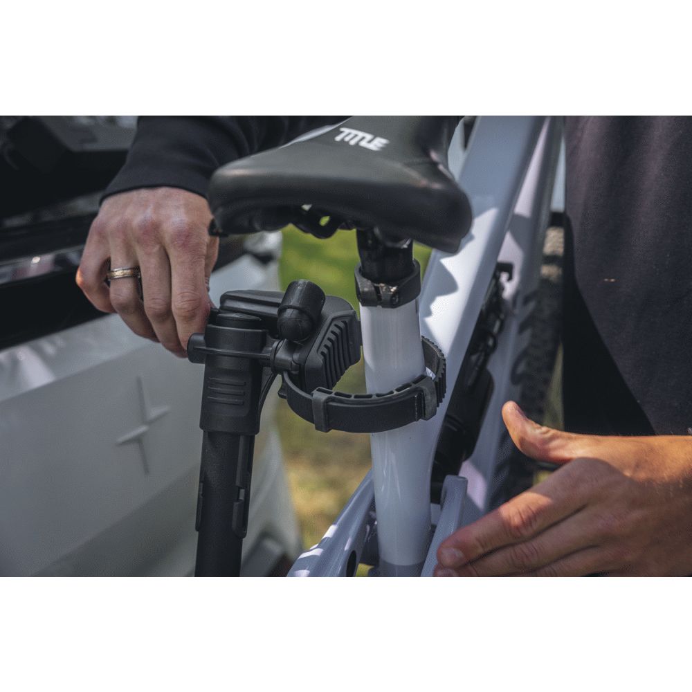 Close-up of a person adjusting a bike seat on a vehicle, loaded to the Thule VeloLite